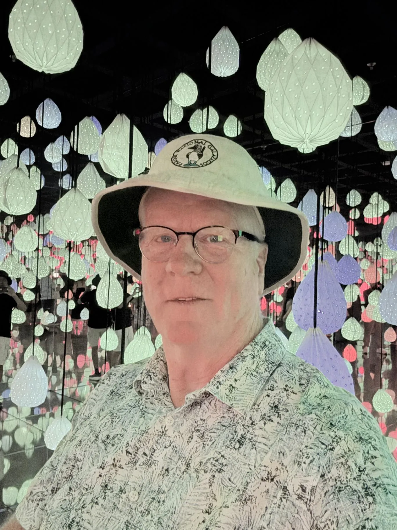 Michael Shoultz wearing a light hat among glowing paper lanterns at an immersive light installation